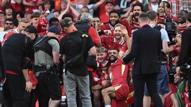 El mediocampista inglés del Liverpool #19 Harvey Elliott, el delantero egipcio #11 Mohamed Salah, el defensor inglés #66 Trent Alexander-Arnold, el defensor inglés #02 Joe Gomez, el arquero brasileño #01 Alisson Becker y el mediocampista japonés #03 Wataru Endo posan junto a sus compañeros después de ganar el partido de la Premier League inglesa entre el Liverpool y el Tottenham Hotspur en Anfield, en Liverpool, noroeste de Inglaterra, el 27 de abril de 2025. El Liverpool ganó el partido 5-1, consagrándose campeón de la Premier League