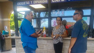 El comisionado Marcos Villanueva (izq.) mientras conversa con dos personas.