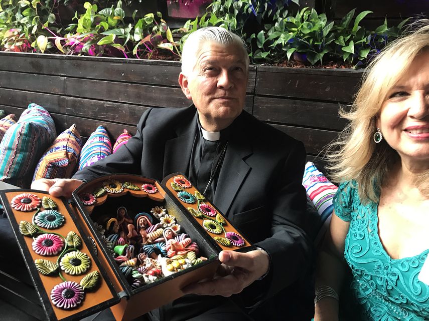 Monseñor Salvador Piñeiro enseña un ratablo hecho por indígenas de Ayacucho, en Perú. A su lado, Violeta Cepeda, presidenta de la Asociación Emergencia Ayacucho, capítulo Miami.