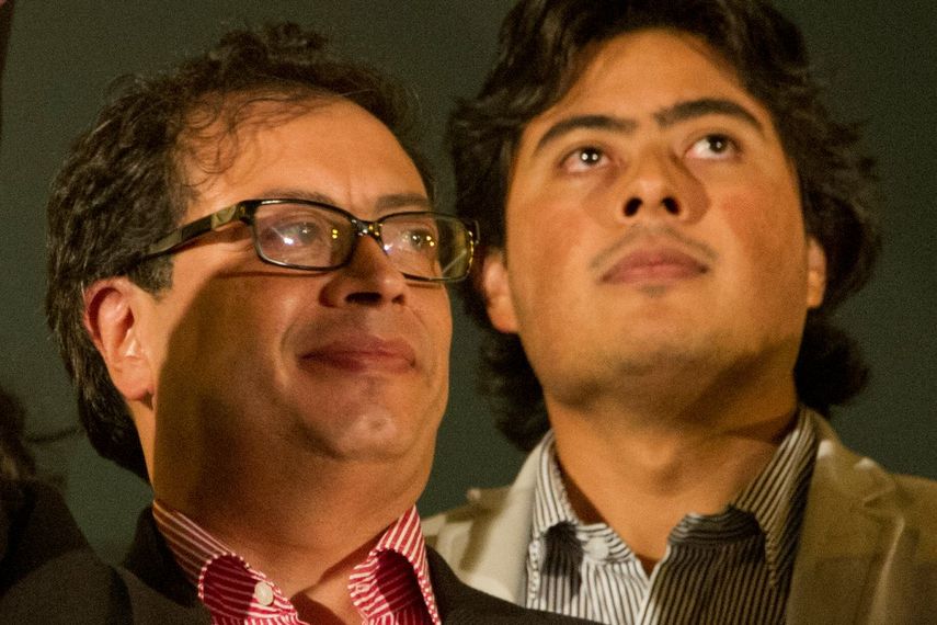 El alcalde destituido de Bogotá, Gustavo Petro (izquierda), saluda a sus simpatizantes mientras su hijo Nicolás Petro observa desde el balcón del ayuntamiento durante una manifestación en el centro de Bogotá el 13 de enero de 2014.&nbsp;
