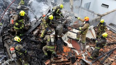 Bomberos trabajan en el lugar del accidente de una avioneta que cayó sobre casas en una zona residencial de Medellín, Colombia, el lunes 21 de noviembre de 2022.&nbsp;