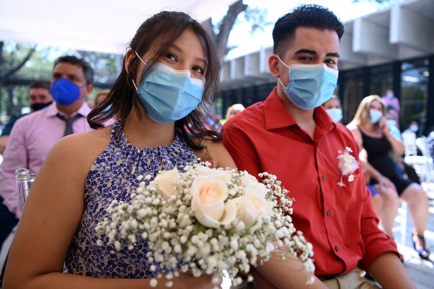 Parejas de recién casados con máscarillas faciales contraen nupcias durante una boda masiva de 44 parejas organizada por el municipio durante la celebración del Día de San Valentín, en el Parque Cuscatlán, en San Salvador, el 14 de febrero de 2021, en medio de la pandemia del COVID.