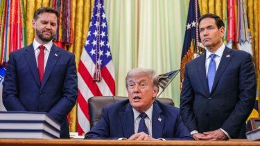 El vicepresidente JD Vance y el secretario de Estado Marco Rubio rodeando al presidente Donald Trump en la Oficina Oval de la Casa Blanca el 27ABR26.
