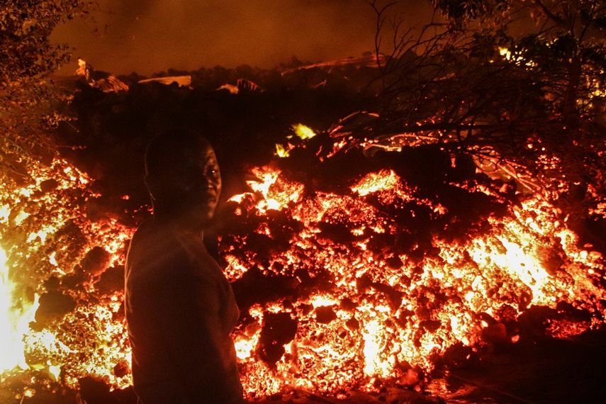 Una persona permanece de pie frente a la lava de la erupción del Monte Nyiragongo, en Buhene, a las afueras de Goma, en las primeras horas del domingo 23 de mayo de 2021, en la República Democrática del Congo
