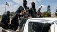 Las fuerzas de seguridad leales al gobierno interino sirio viajan en la parte trasera de un vehículo que circula por una carretera en la ciudad de Latakia, en el oeste de Siria, el 9 de marzo de 2025.