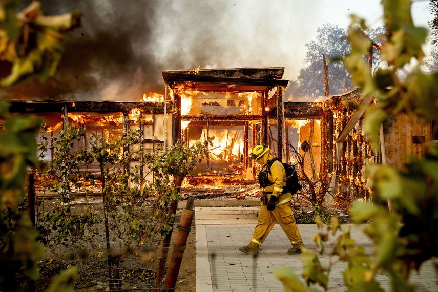 El bombero Joe Zurilgen camina frente a una casa envuelta en llamas en Healdsburg, California, el domingo 27 de octubre de 2019.&nbsp;