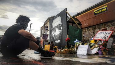 El manifestante Trevor Rodr&iacute;guez observa sentado un monumento improvisado en el sitio donde George Floyd falleci&oacute;.&nbsp;