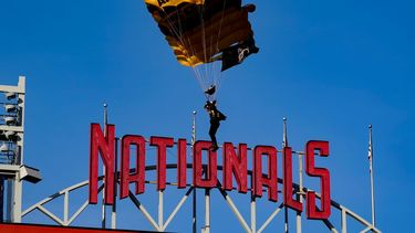 Un miembro del equipo de paracaidistas Golden Knights del Ejército de Estados Unidos desciende al National Park antes de un partido entre los Nacionales de Washington y los Diamondbacks de Arizona el miércoles 20 de abril de 2022, en Washington. &nbsp;
