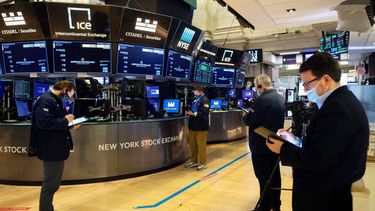 Agentes de la Bolsa de Nueva York trabajan en el piso de remate.