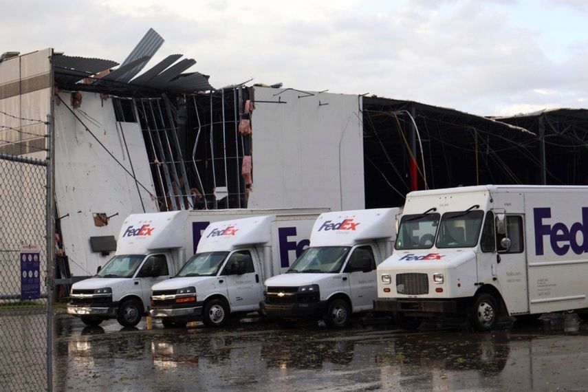 Camiones de FedEx se ven ante un centro dañado de FedEx tras el paso de un tornado en Portage, Michigan, el martes 7 de mayo de 2024.