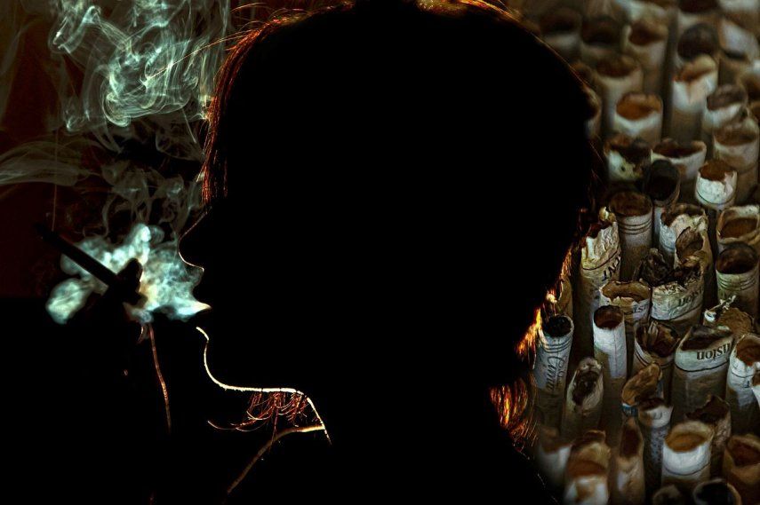 Una mujer exhala el humo del cigarillo por la boca.&nbsp;