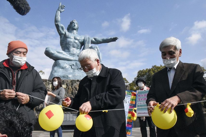 Asistentes desinflan globos simbolizando la esperanza de neutralizar y destruir la ojivas nucleares, durante un acto en el Parque de la Paz de Nagasaki, en el sur de Japón, el 22 de enero de 2021.&nbsp;