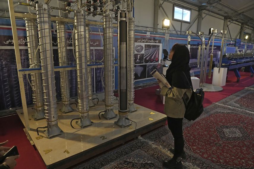 Una estudiante observa centrifugadoras nucleares de fabricación iraní en una exposición en Teherán, Irán.