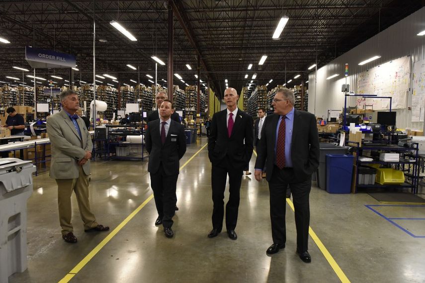 Foto en el interior de una de las plantas de distribución de KLX. El segundo, de izq a derecha, es el vicepresidente de la empresa, John Cuomo. A su lado, el gobernador Rick Scott.&nbsp;