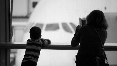 Una mujer y su hijo esperan la llegada de un familiar en el aeropuerto.&nbsp;