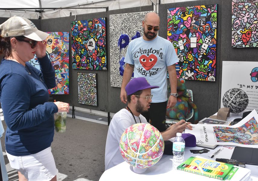 El artista cubanoamericano V&iacute;ctor Garc&iacute;a, autor del p&oacute;ster del Carnaval de Miami, firma su obra para los asistentes a Carnaval on the Mile.&nbsp;