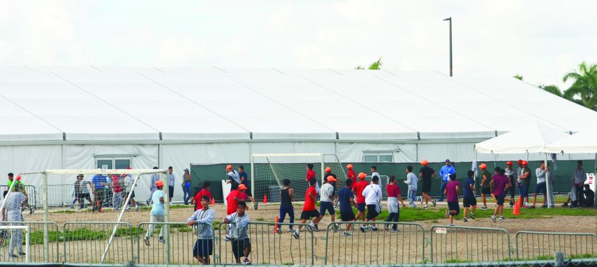 En esta foto tomada desde las afueras del refugio, los niños corren en un campo de fútbol. Al fondo, están las carpas donde se aloja a parte de los menores.