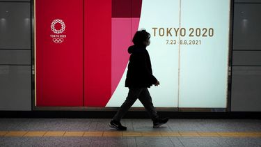 Una mujer con mascarilla camina frente a un anuncio de los Juegos Olímpicos enTokio, el 6 de abril de 2021&nbsp;