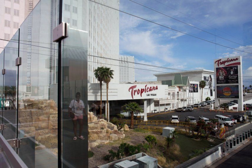 Una persona, reflejada en las ventanas, camina cerca del hotel Tropicana en Las Vegas, el martes 16 de mayo de 2023.