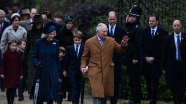 El rey Carlos III flanqueado por la reina consorte Camilla saludan a los miembros del público cuando llega al tradicional servicio de Navidad de la familia real en la iglesia de Santa María Magdalena en Sandringham, Norfolk, este de Inglaterra, el 25 de diciembre 2022.