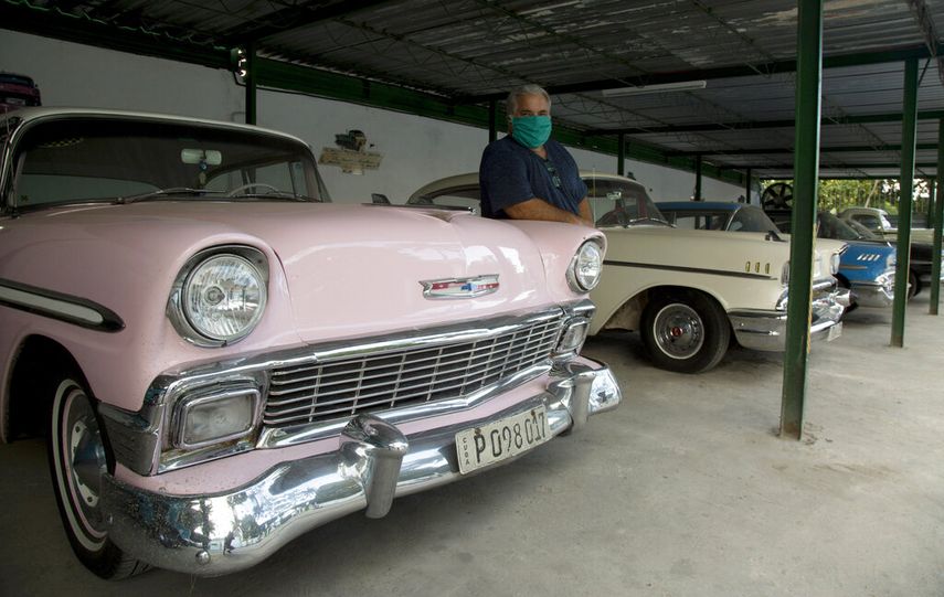 Julio &Aacute;lvarez posa para una foto con sus autom&oacute;viles americanos antiguos que los turistas usan para pasear por La Habana, Cuba, el viernes 24 de abril de 2020. Como s&oacute;lo se permiten actividades esenciales por la cuarentena para contener la propagaci&oacute;n del nuevo coronavirus, los autos de &Aacute;lvarez est&aacute;n estacionados, los turistas han desaparecido y sus conductores permanecen en casa.