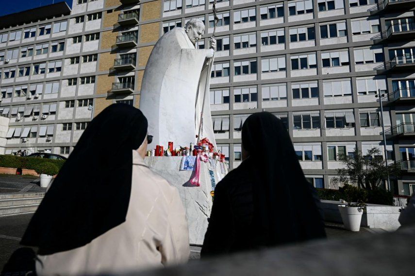 Monjas oran cerca de la estatua de Juan Pablo II fuera del Hospital Universitario Gemelli, donde el papa Francisco está hospitalizado con neumonía, en Roma, el 3 de marzo de 2025.