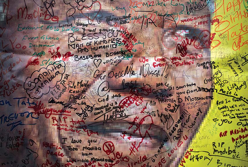 Póster de Nelson Mandela, en una calle en Soweto, donde numerosas personas han escrito mensajes para el expresidente. (AP)