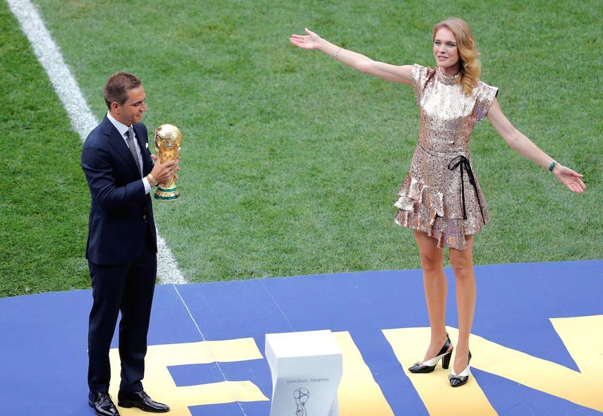 El exfutbolista alemán Philipp Lahm (i) y la modelo rusa Natalia Vodianova (d) portan el trofeo del Mundial antes del partido final de Rusia 2018.&nbsp;