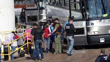 Trabajadores esposados suben a un autob&uacute;s despu&eacute;s de una redada migratoria en la planta av&iacute;cola de Koch Foods Inc. en Morton, Mississippi, el 7 de agosto de 2019.&nbsp;