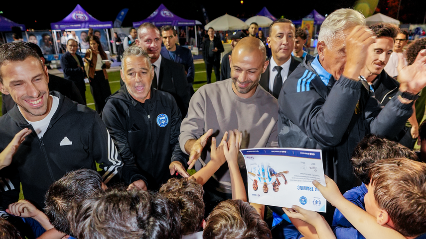 Maxi Rodríguez (primero izq. a der.) y Javier Mascherano (tercero) saludan a jóvenes talentos del fútbol y firman autógrafos.
