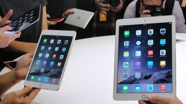 Clientes muestran la nueva tableta de Apple.