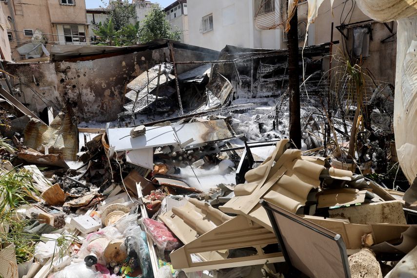 La espuma utilizada por los bomberos cubre los escombros tras un impacto, supuestamente provocado por un misil o por fragmentos de un interceptor, en un barrio residencial de la zona de Petah Tikva, Israel, el 22 de marzo de 2026.