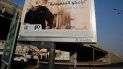 Un hombre pasa bajo un cartel con un anuncio de la petrolera estatal saudí Aramco, con el mensaje en árabe Saudi Aramco, pronto en el mercado de valores, en Yeda, Arabia Saudí, el 12 de noviembre de 2019.