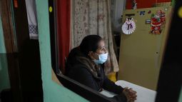 La migrante venezolana Yaquelin Timaure se ve reflejada en un espejo durante una entrevista en su casa en Bogotá, Colombia, el lunes 21 de diciembre de 2020.