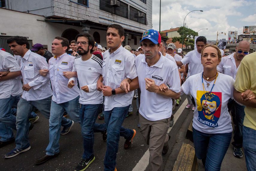 El líder opositor Henrique Capriles (2-d) y la esposa del líder opositor Leopoldo López, Lilian Tintori, participan en una manifestación contra el gobierno nacional.