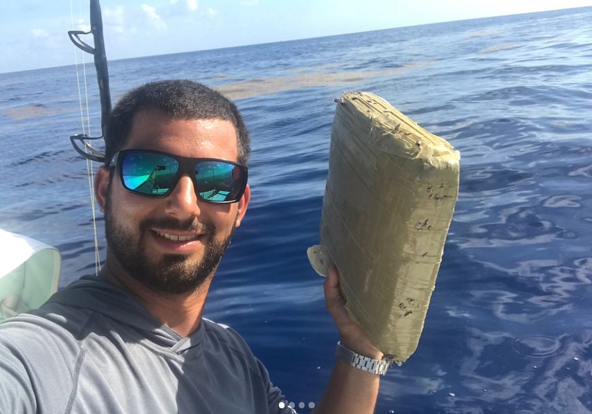 El fotógrafo Jorge Bustamante sostiene el paquete de marihuana que encontró en las costas de Pompano Beach.