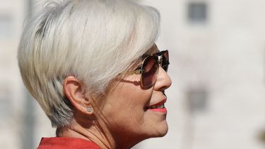 Una mujer de la tercera edad sonríe mientras luce su corte de cabello y maquillaje