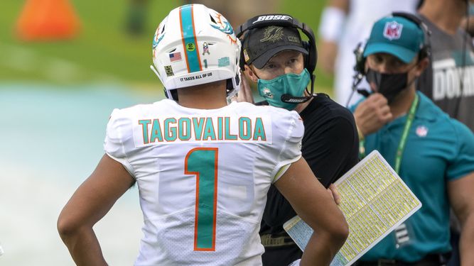 El mariscal de campo de los Dolphins, Tua Tagovailoa (1), habla con el entrenador de mariscales de campo de Miami, Robby Brown, durante un juego de fútbol americano, el domingo 1 de noviembre de 2020