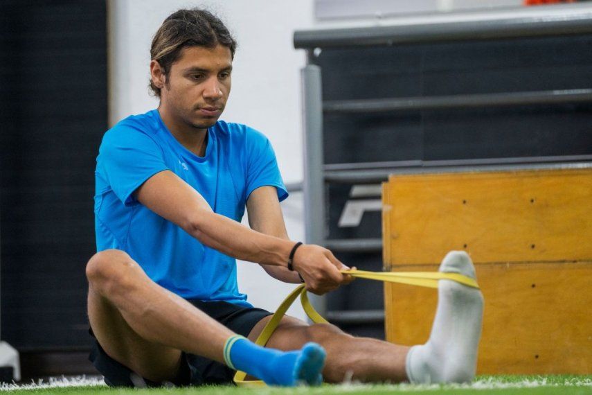 El atleta guatemalteco Luis Grijalva se estira durante un entrenamiento en el Estadio Nacional de la Ciudad de Guatemala, el lunes 25 de marzo de 2024.
