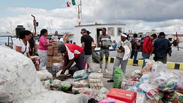 Activistas del Convoy Nuestra América y funcionarios cubanos descargan ayuda humanitaria del buque Maguro.&nbsp;