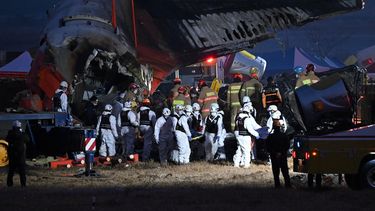 Bomberos y personal de rescate llevan el cuerpo de una víctima cerca del lugar donde un avión Boeing 737-800 de Jeju Air se estrelló y estalló en llamas en el Aeropuerto Internacional de Muan en la provincia de Jeolla del Sur, a unos 288 kilómetros al suroeste de Seúl el 29 de diciembre de 2024. Un avión de Jeju Air que transportaba a 181 personas desde Tailandia a Corea del Sur se estrelló al llegar, se estrelló contra una barrera y estalló en llamas, dejando a todos menos dos muertos.