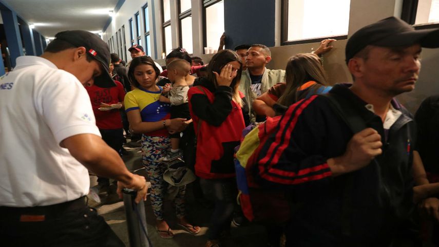 Inmigrantes venezolanos esperan para entrar a Perú por la frontera con Ecuador.