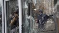 Un hombre toma una fotografía de un vidrio roto en un puesto policial vandalizado durante una protesta en Almaty, Kazajistán, el 5 de enero de 2022. 