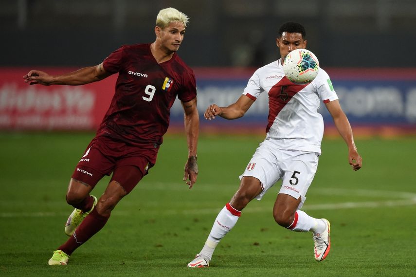 El venezolano Eric Ramírez y el peruano Marcos López compiten por el balón durante su partido de fútbol de clasificación sudamericano para la Copa Mundial de la FIFA Catar 2022