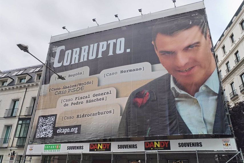 Hazte Oír despliega una lona frente al Congreso de España con una imagen de Pedro Sánchez acompañado del lema Corrupto