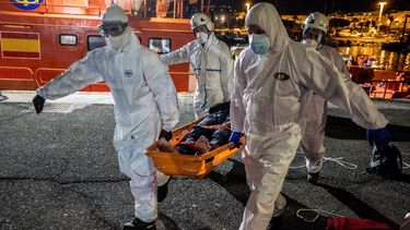 Un migrante es trasladado en camilla desde un barco de rescate en el puerto de Arguineguín, en la isla de Gran Canaria, España, el sábado 16 de enero de 2021.&nbsp;