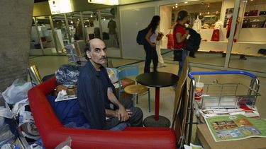 Merhan Karimi Nasseri sentado entre sus pertenencias en la Terminal 1 del aeropuerto Roissy Charles De Gaulle, en París el 11 de agosto de 2004. Nasseri fue el hombre que inspiró la película La Terminal de Steven Spielberg