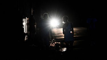 Una pareja de cubanos camina por una calle durante un apagón nacional causado por una falla de la red eléctrica en La Habana el 15 de marzo de 2025.AFP