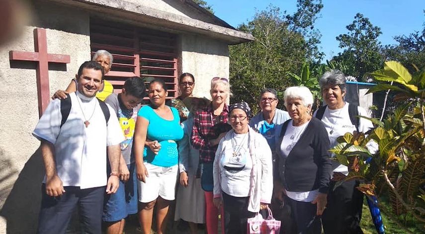 El sacerdote cubano Bladimir Navarro (izq) junto a varios feligreses.&nbsp;