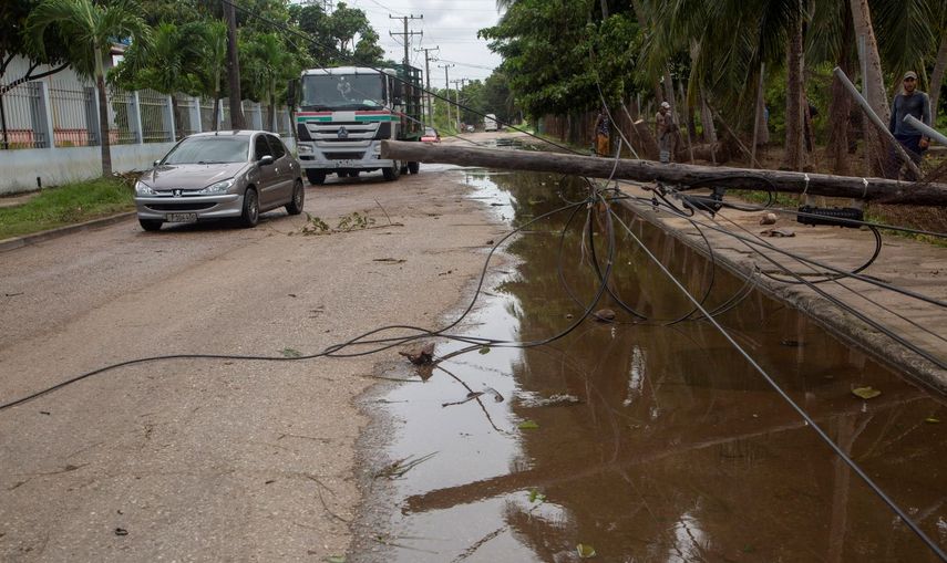 Un poste eléctrico se apoya en las líneas eléctricas caídas tras el paso del huracán Ian en La Habana, Cuba, el miércoles 28 de septiembre de 2022